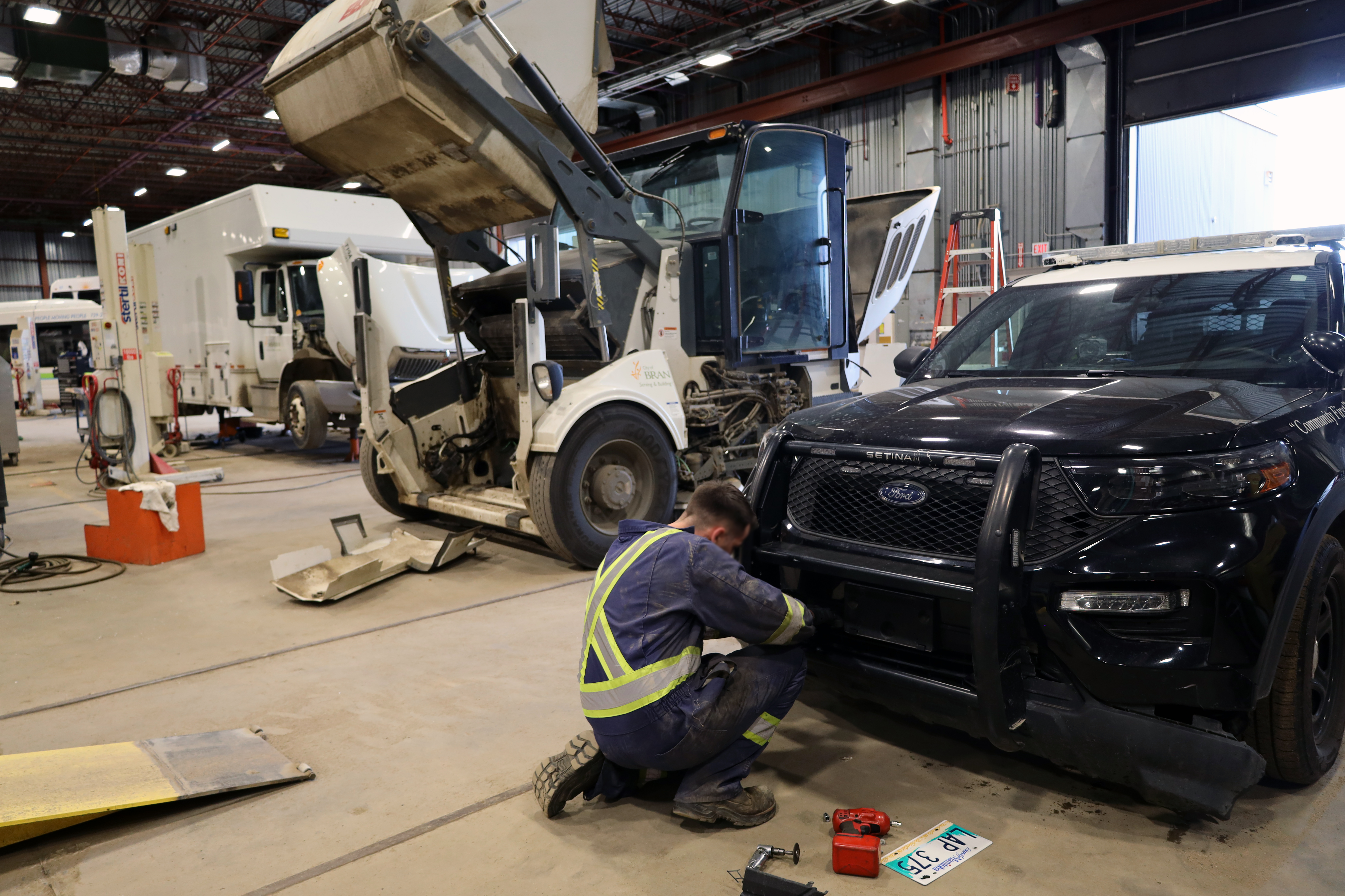 mechanic working in garage on police cruiser