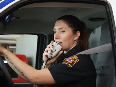 Member of Brandon Fire & Emergency Services driving in an ambulance while talking on the radio