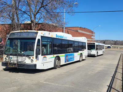 Two buses sitting at the bus terminal downtown