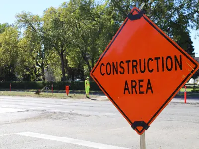Construction Area sign with a flag person in the background.